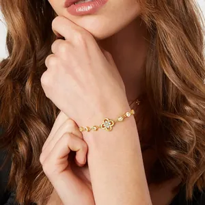 Elegante bracciale a quadrifoglio placcato oro 14K con diamanti sul polso di una donna