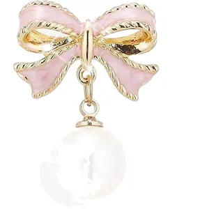 Pendientes de lazo en esmalte rosa con borde dorado y elegantes perlas blancas