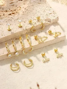 Gros plan de boucles d'oreilles dorées avec étoiles, lunes et zircons sur pierre