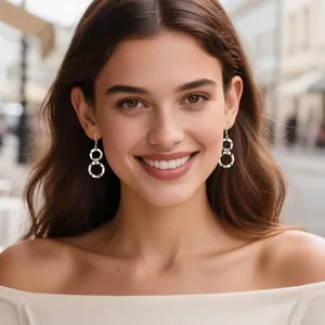 Gros plan d'une femme portant des boucles d'oreilles doubles anneaux argentés martelés