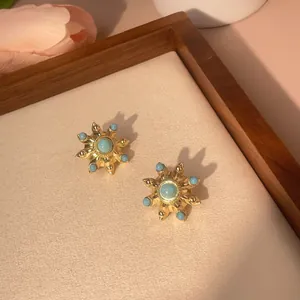 Detail of vintage turquoise sunburst earrings with gold plating and blue stone inlay