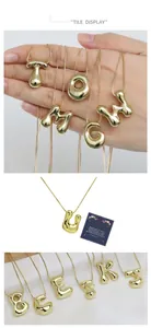 Macro detail of 3D puff bubble letter pendants with shiny gold plating finish