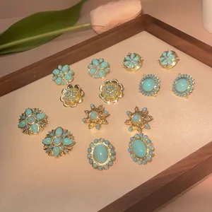 Vintage gold plated brass earrings with turquoise stones in elegant retro floral patterns