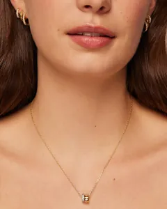 Detailaufnahme eines Models mit goldener Halskette und passenden Creolen mit Zirkonia