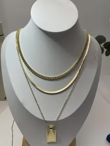 Dettaglio della collana a strati dorata con pendente a cerchio intrecciato e maglia