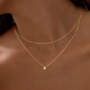 Double layered gold plated necklace with shimmering zircon pendant worn by model