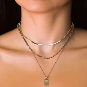 Collana a tre strati in ottone dorato con catena a torsione e pendente strutturato da donna