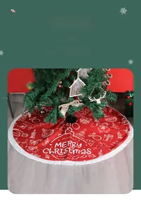 Detail of red Christmas tree skirt with white tassels and Merry Christmas holiday print