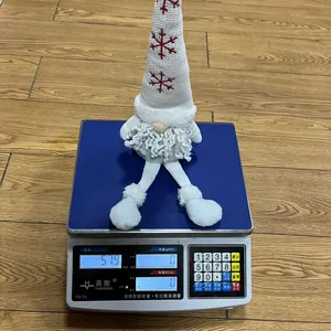 Detailed view of a Nordic plush Christmas gnome being weighed on an electronic scale