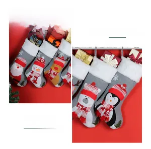 Detail of Christmas stockings with cute characters like Santa and Reindeer hanging on red wall