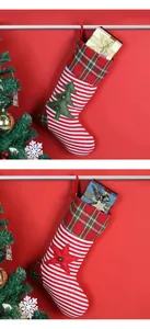 Detail von gestrickten Weihnachtssocken mit Baum- und Stern-Patches auf festlichem Rot