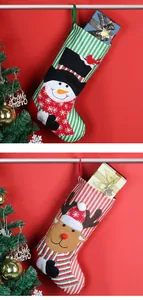 Detail of Christmas stockings with snowman and reindeer patches on striped fabric