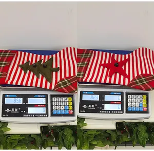 Details von gestrickten Weihnachtssocken mit Baum- und Stern-Patches auf einer Digitalwaage