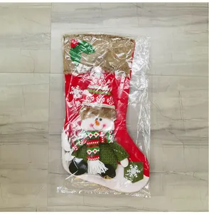Detail van rode kerstsok met sneeuwvlokpatronen en een 3D-pluche pop als decoratie
