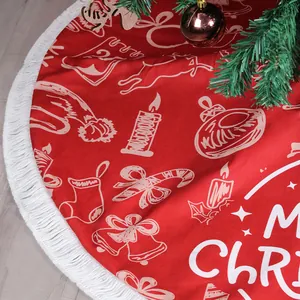 Red Christmas tree skirt with white festive patterns and tassel trim on wooden floor