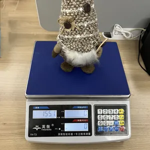 Detail shot of a handmade coffee gnome on a scale showing a weight of 155.1 grams