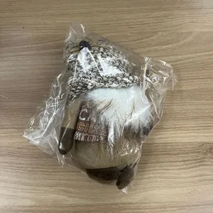 Detail of coffee gnome plush in packaging showing knitted hat with coffee bean decor