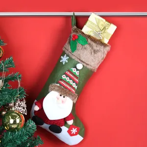 Grote groene kerstsok met kerstmanpop en pluchen rand voor feestelijke decoraties