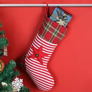 Gestrickter Weihnachtsstrumpf mit rot-weißen Streifen und Karomuster für die Feiertage