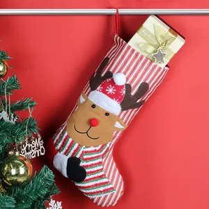 Christmas stocking with 3D reindeer design hanging near a festive tree and gift box