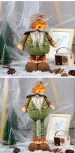 Detail of autumn gnome plush with green overalls and orange maple leaf hat decoration