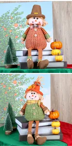 Close-up of autumn plush scarecrow dolls with long striped legs and festive sunflower hats