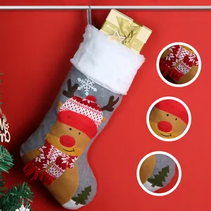 Gray felt Christmas stocking with 3D deer head decoration on festive red background