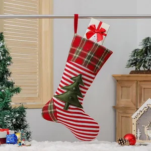 Red and white striped knitted Christmas stocking with green tree appliqué and bells