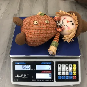 Detail shot of harvest scarecrow plush doll on an electronic scale weighing 168.6 grams