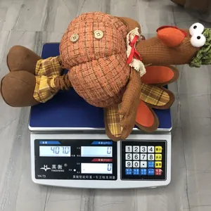 Detail showing plush Thanksgiving turkey doll weighing approximately 407 grams on a scale