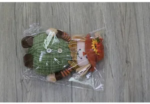 Close-up of autumn sunflower doll ornament with striped arms and orange hat detail