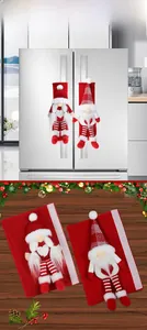 Detail of Christmas gnome refrigerator handle covers on silver fridge and wooden background