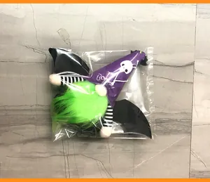 Detail of Halloween gnome plush with bat wings and purple BOO hat in protective packaging