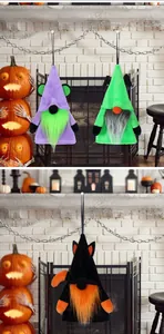 Three plush Halloween gnomes hanging in front of a cozy white fireplace with pumpkins