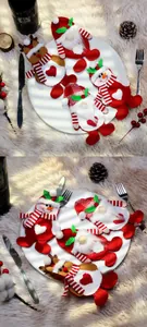 Detail of Christmas cutlery holders with gnome reindeer and snowman on a white plate