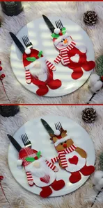 Detail of Christmas cutlery holders featuring Santa, snowman, and reindeer on dinner plates