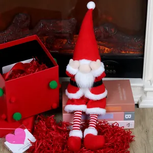 Detail eines Weihnachts-Gnomes mit langen Beinen und Streifen neben einem Kamin