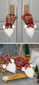 Detail of two knitted Christmas gnome door hangers with red and green patterns