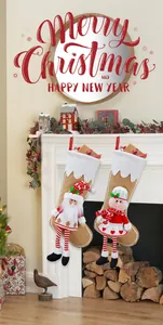 Close-up of rustic Christmas stocking set with plush dolls on white fireplace