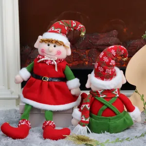 Christmas plush elf dolls with red and green outfits on a cozy fireplace background
