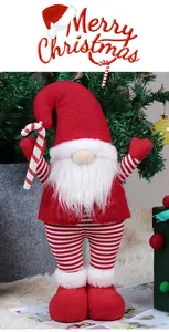 Detail of Christmas gnome plush with red knitted hat and candy cane in festive setting