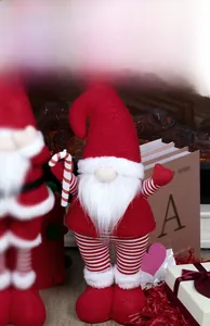 Detail showing the retractable mechanism of the Christmas gnome with a red hat and candy cane