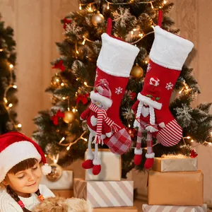 Hanging Christmas stockings with snowman and elf 3D dolls on a decorated holiday tree