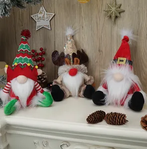 Detailed view of three Christmas gnomes with sequins and reindeer antlers on a white table