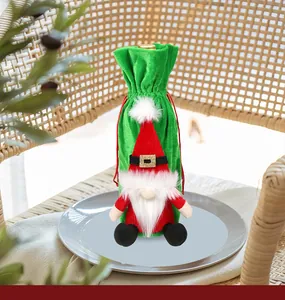 Close-up of green velvet Christmas gnome wine bottle cover with red sequin hat on a plate