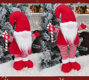 Detail of Christmas gnomes with knitted hats and candy canes on a snowy backdrop