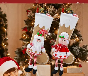 Detail of Christmas stocking hangers featuring 3D Santa and girl plush doll decorations