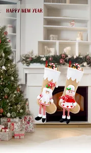 Detail of Christmas stocking set with Santa and girl doll figures hanging on fireplace