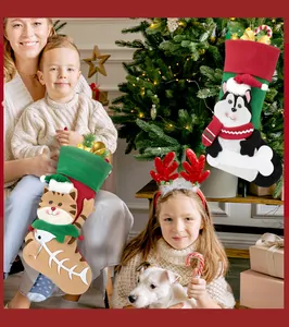 Detail of Christmas cat and dog stockings with bells and bone charms on a tree