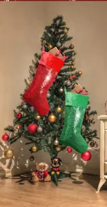 Close-up of sparkling red and green sequined Christmas stockings hanging by a festive tree